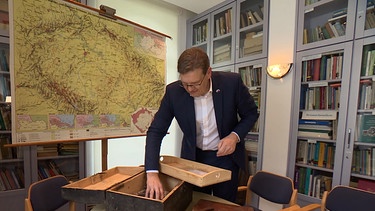 Steffen Hörtler vor einer Landkarte in seinem Büro. | Bild: BR
