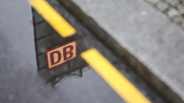 25.03.2024, Berlin: Ein Logo der Deutschen Bahn spiegelt sich in einer Pfütze vor dem Berliner Hauptbahnhof. Foto: Hannes P. Albert/dpa +++ dpa-Bildfunk +++ | Bild: dpa-Bildfunk/Hannes P. Albert