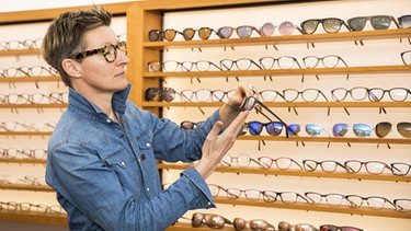 Frau sucht beim Optiker eine Brille aus | Bild: picture-alliance/dpa