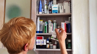 Eine Frau holt ein Medikament aus der Hausaoptheke | Bild: picture-alliance/dpa/ JOKER/Paul Eckenroth