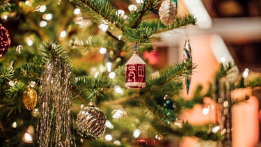 Christbaumkugeln und Lametta an einem Weihnachtsbaum. | Bild: BR/Johanna Schlüter