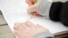 Hände, die einen Brief schreiben. | Bild: BR