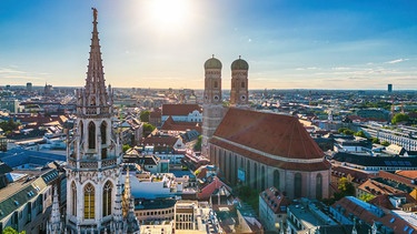 Ansicht von München mit dem Rathausturm im Vordergrund und der Frauenkirche | Bild: picture alliance / Zoonar | Christian Offenberg