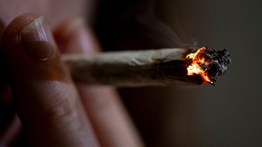 Eine Person raucht einen Joint. | Bild: dpa-Bildfunk/Fabian Sommer