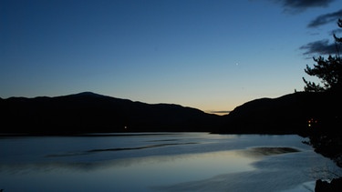 Abendhimmel mit letztem Sonnenlicht über einem See. Die erste Dämmerungsphase, die nach Sonnenuntergang einsetzt, wird bürgerliche Dämmerung genannt. Der Tag wird langsam zur Nacht. | Bild: colourbox.com